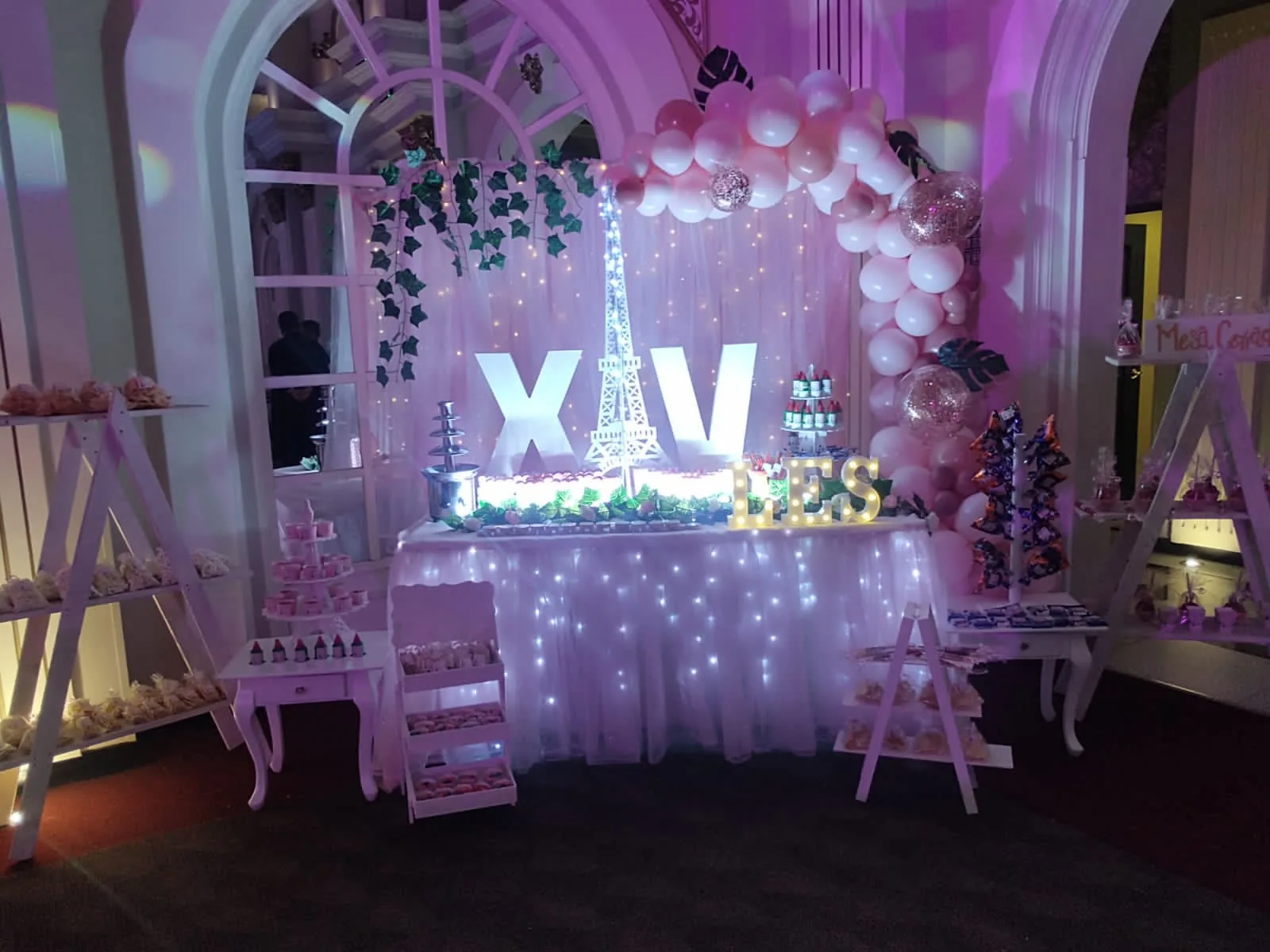 mesa de dulces para XV años con decoración rosa y luces