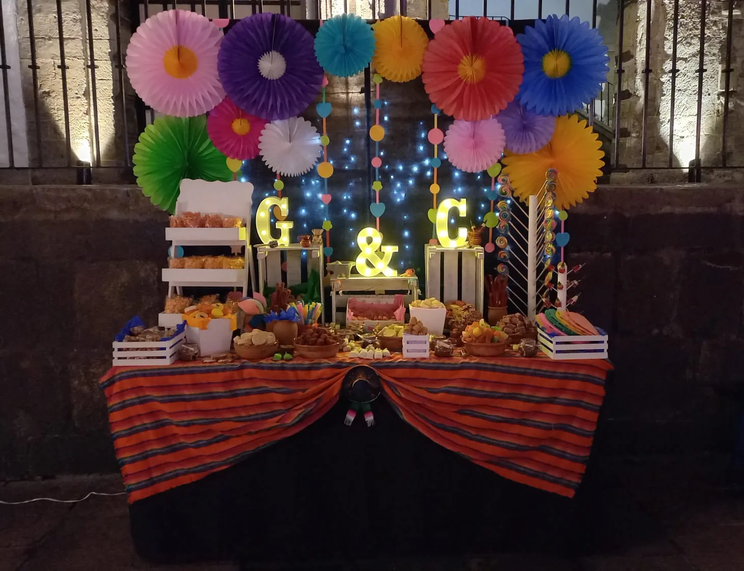 mesa de dulces mexicana para fiesta con papel picado
